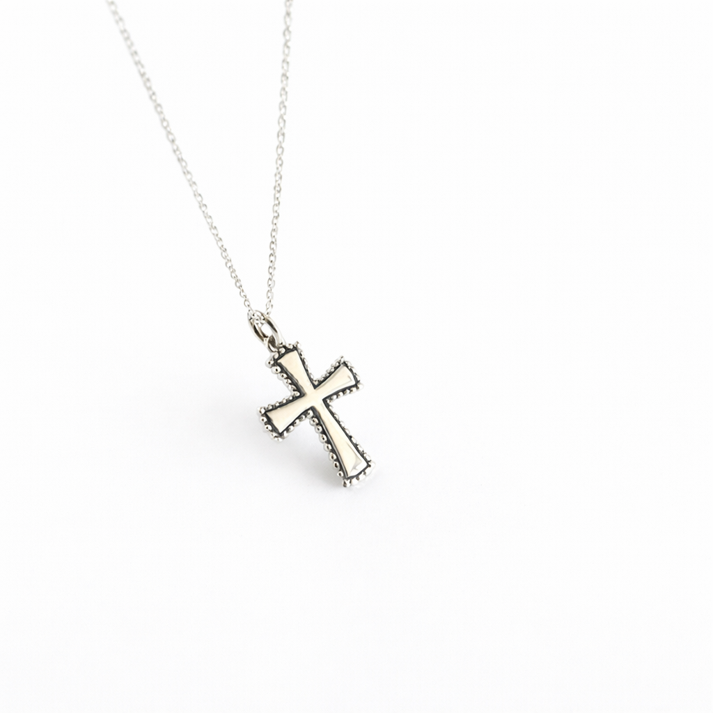 Silver cross pendant necklace on a white background
