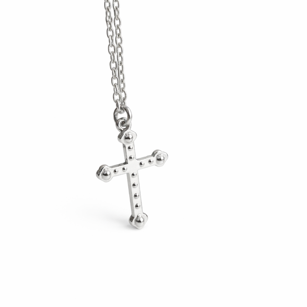 Silver cross pendant on a chain against a white background