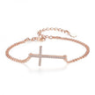 Rose gold bracelet with a diamond-studded cross on a white background